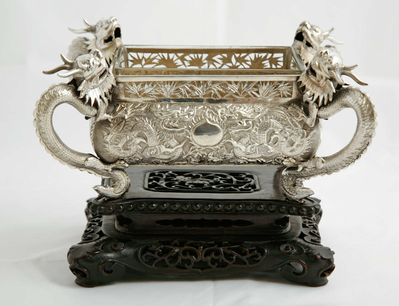 A Chinese Export Silver Jardiniere made by the firm of Hung Chong & Co. who were supplying silver to international clientele in Canton and Shanghai in the late nineteenth century.
This dish has four dragons at each corner and sits on the original