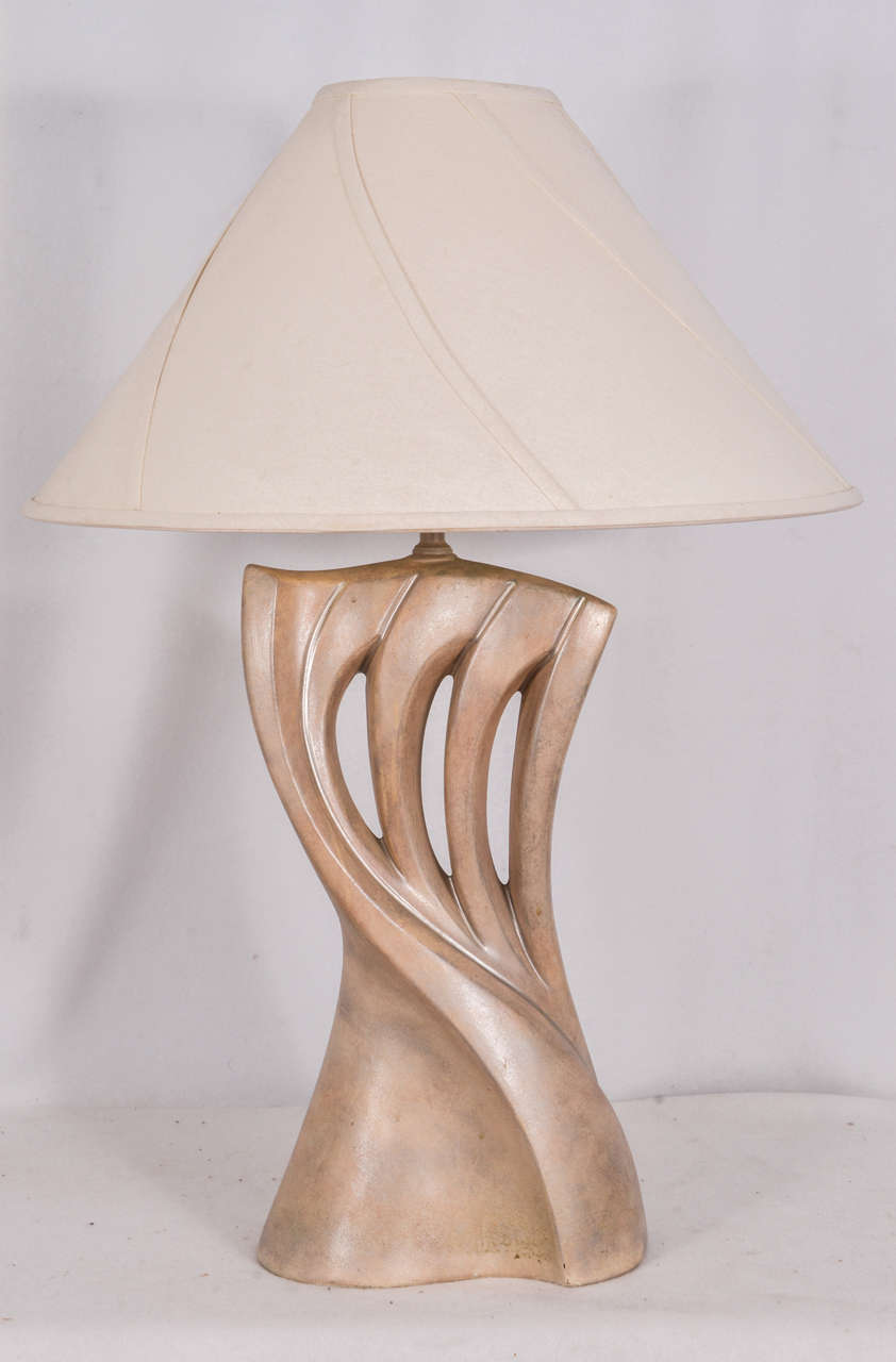 Mid-Century table lamps with a sensual-graceful flowing figural flair. The photograph does not show the detail in the lampshade but they have the same sweeping curve applied to the surface of the lampshade as seen in the table lamps. 
Shades are