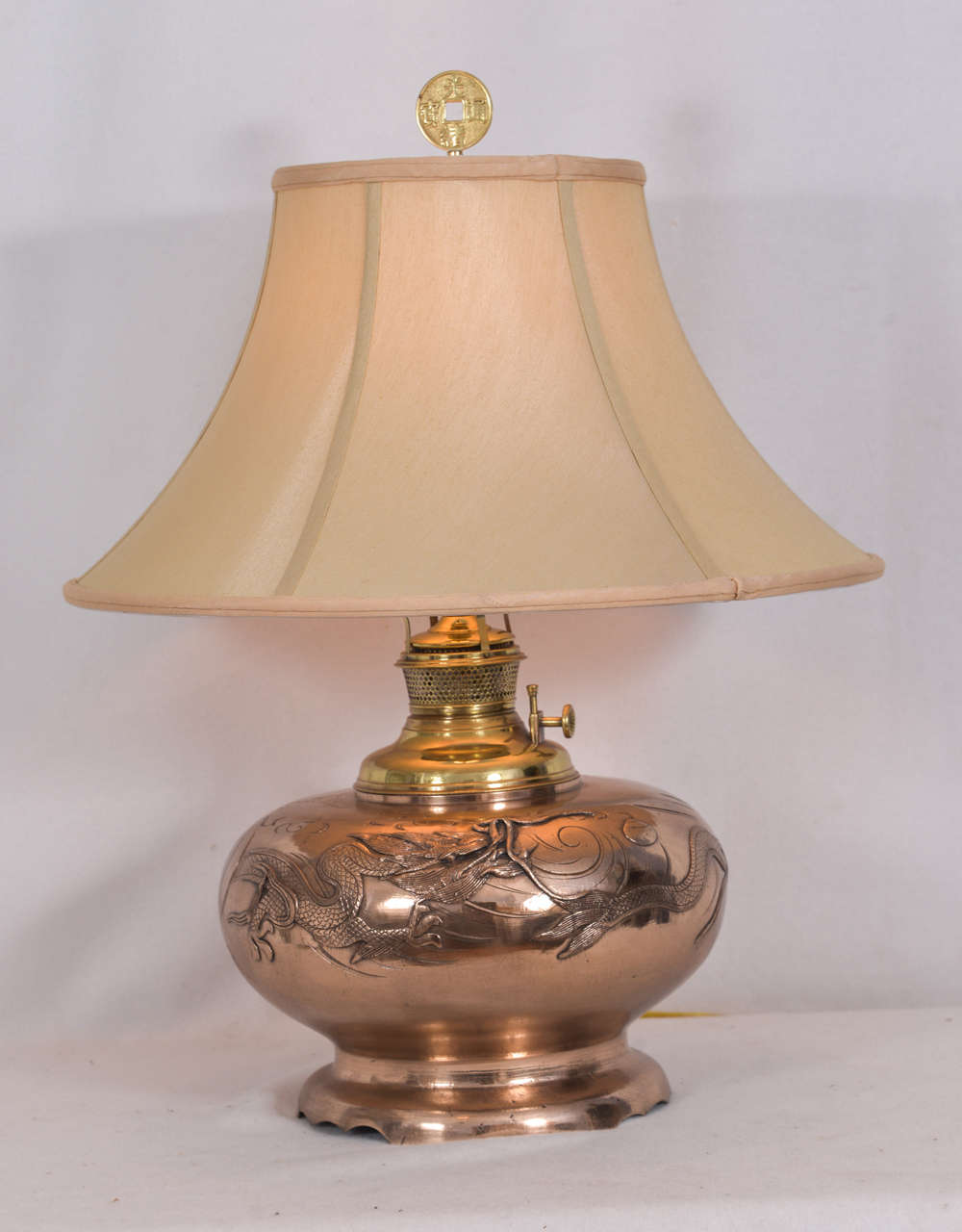 Cast copper, Asian design, converted oil lamp with an Asian finial. The lamp has been polished and sealed and electrified. The lamp is priced without the lampshade shown. The oil font was made by the Aladdin lamp company in early 1900s and inserted