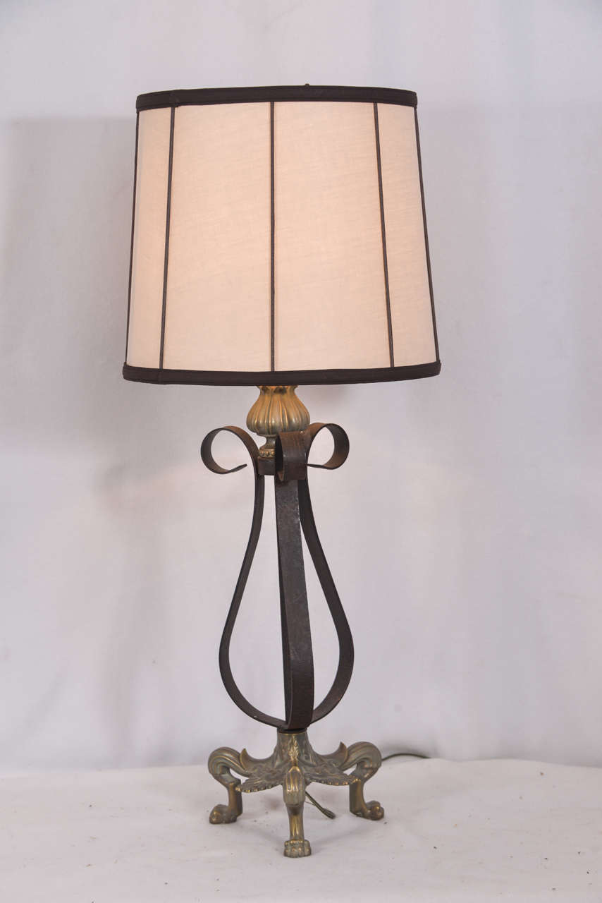 Neoclassical design table lamps, pair, featuring cast brass legs and cast brass acorn at the top and black iron. Lamps are priced without the lampshade. Lampshade shown on the lamp is 18