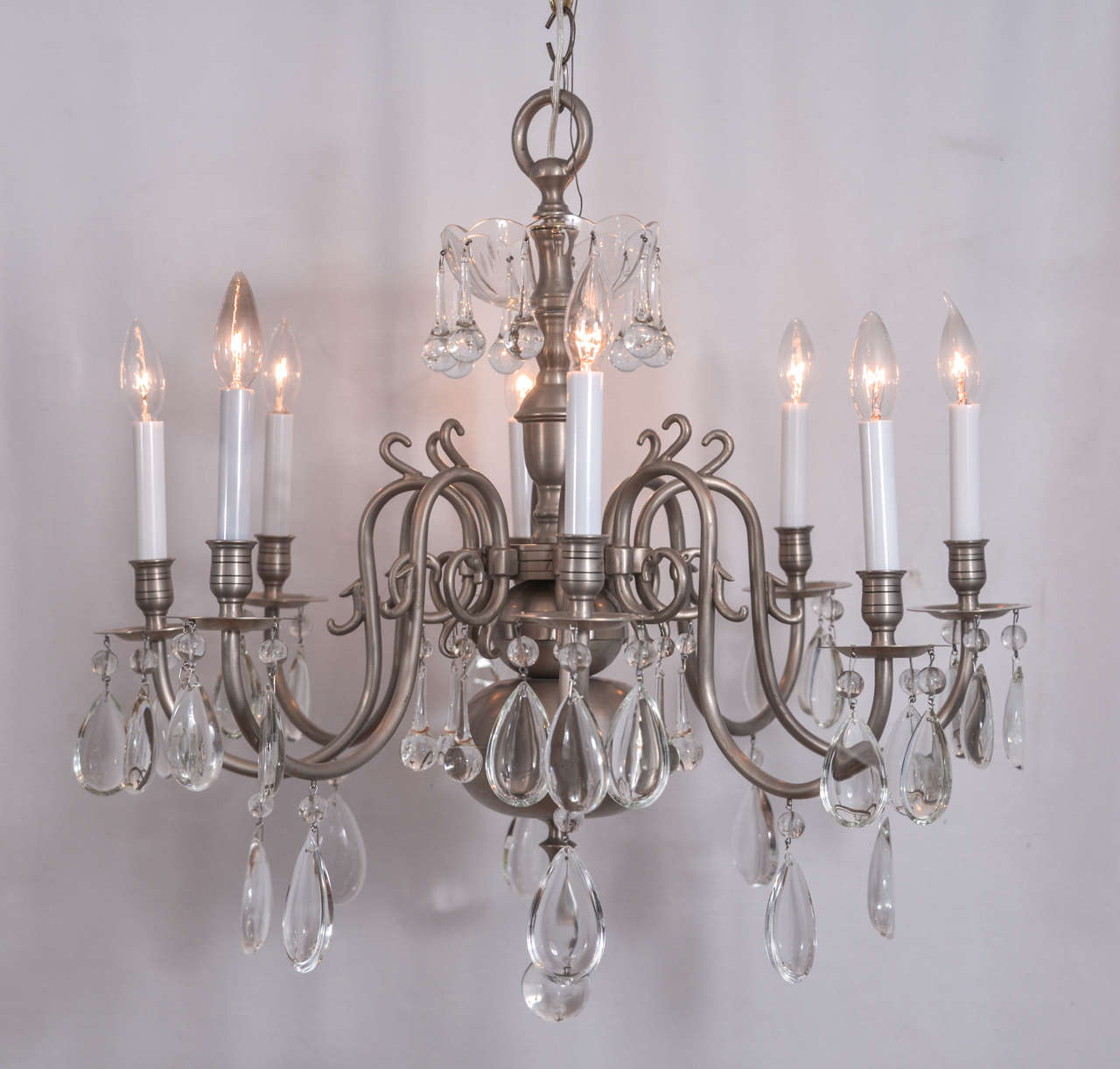 Cast brass with brushed nickel finish Williamsburg style with oyster cut prisms which gives a sense of elegance that is unusual in a Williamsburg chandelier.
The initial height of this fixture is 25