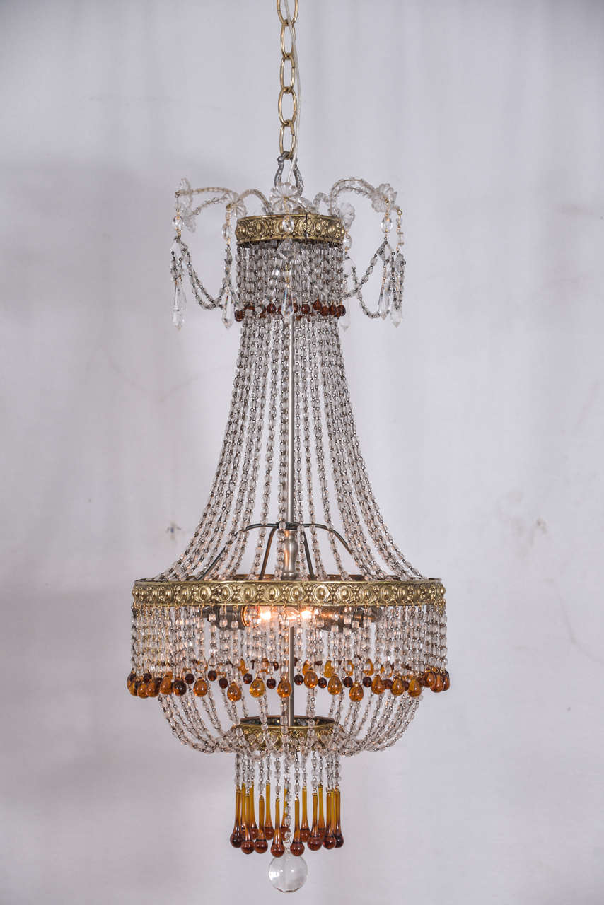Beautiful French, two-light, fully restored, vintage crystal beaded basket fixture, totally rewired to UL approved standards, accented with amber crystals and whimsical draped crystal chains and prisms at the top. The fixture is 22" long