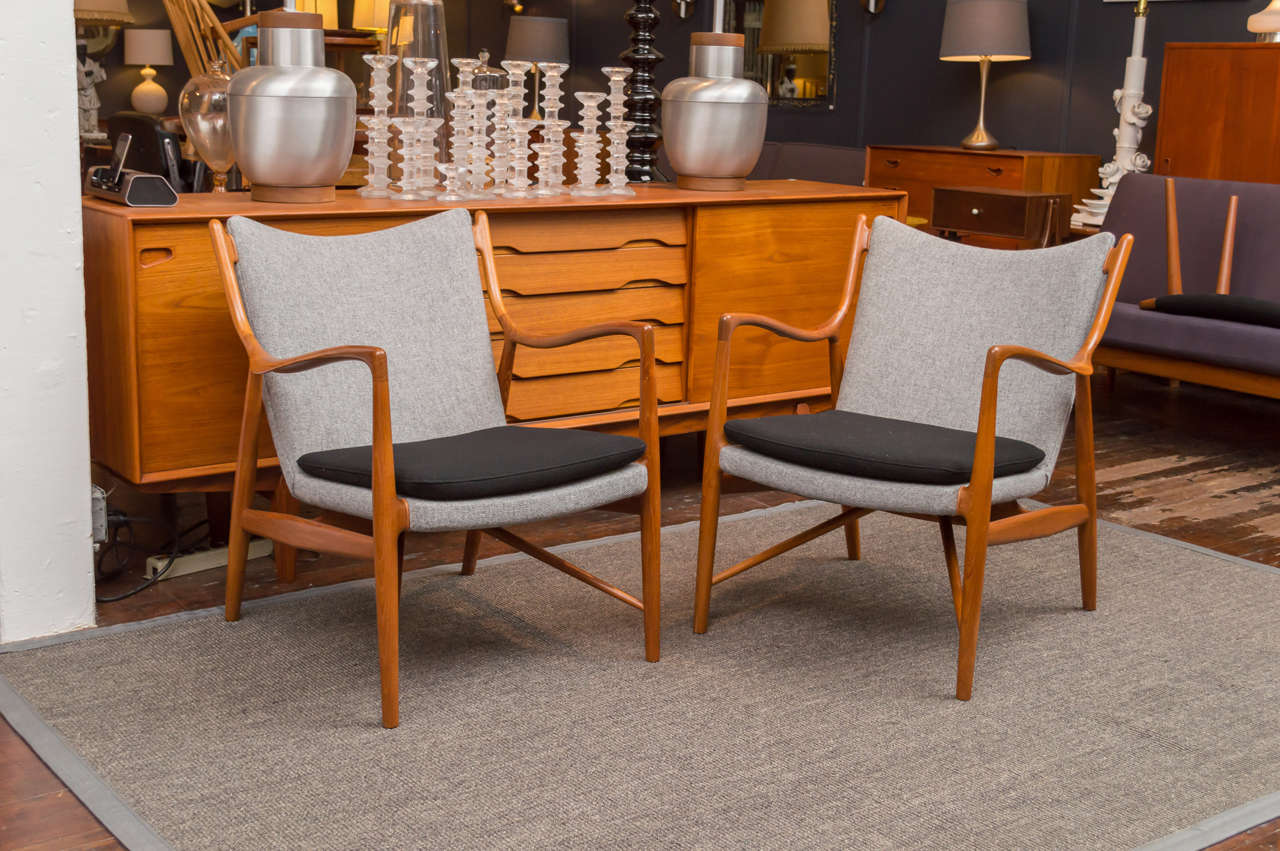 Rare matched pair of original finish teak armchairs newly upholstered in Danish wool.
Acquired from the original owner's estate, stamped with retailer and cabinet makers mark.