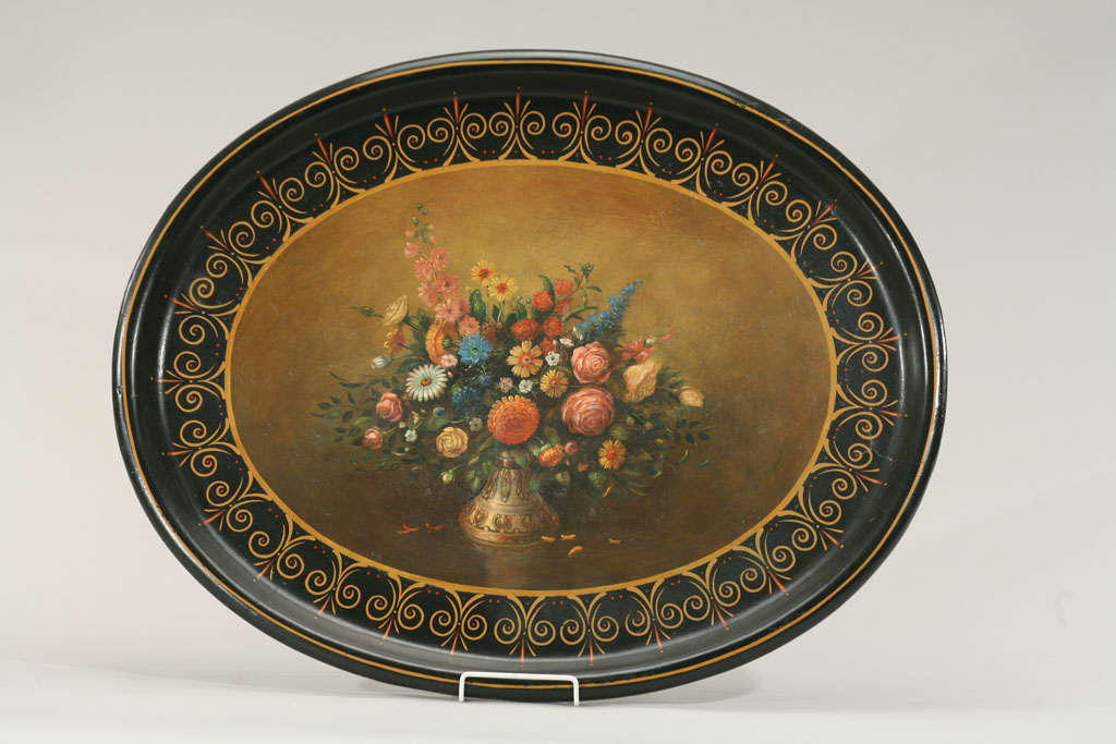 Ce grand plateau ovale ferait une jolie table basse ou une suspension murale décorative. Peint de façon réaliste avec une merveilleuse décoration centrale florale de nature morte et des couleurs de fond douces. La bordure en laque noire contraste et