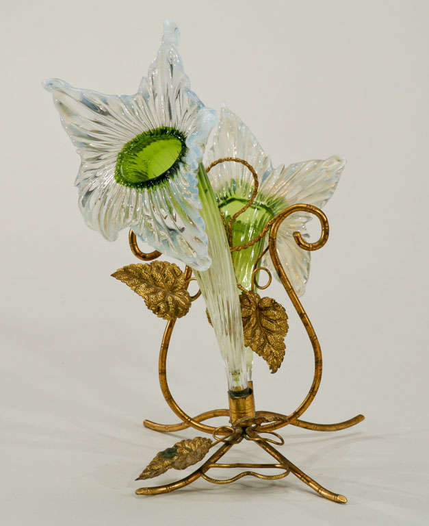 This lovely hand blown crystal epergne is suggestive of a pair of naturalistic flowers done in two colors. The reactive opalescent opening on the green stems is evocative of a floral sculpture. This can be used as a vase or stand on it's own as a
