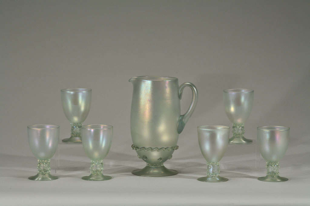 This rare and complete service for 12 includes the water goblets and matching pitcher. The color was one of Frederick Carder's favorites, a variation of the 