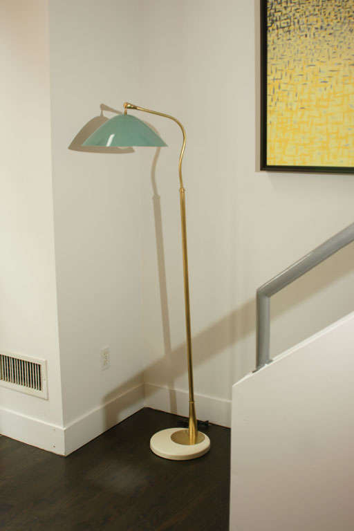 Italian swivel floor lamp by Stilnovo.

Green adjustable shade connected to a swivel brass arm standing on a brass pole and enameled. Metal base. Published. Rewired.