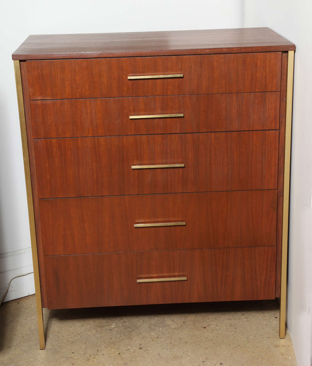 Mid Century Teak and Brass 5 Drawer Highboy Dresser in the style of Paul McCobb's Irwin collection. Complete with Brass legs, sides and pulls. Stamped Ramseur Furn. Co.  Refinished