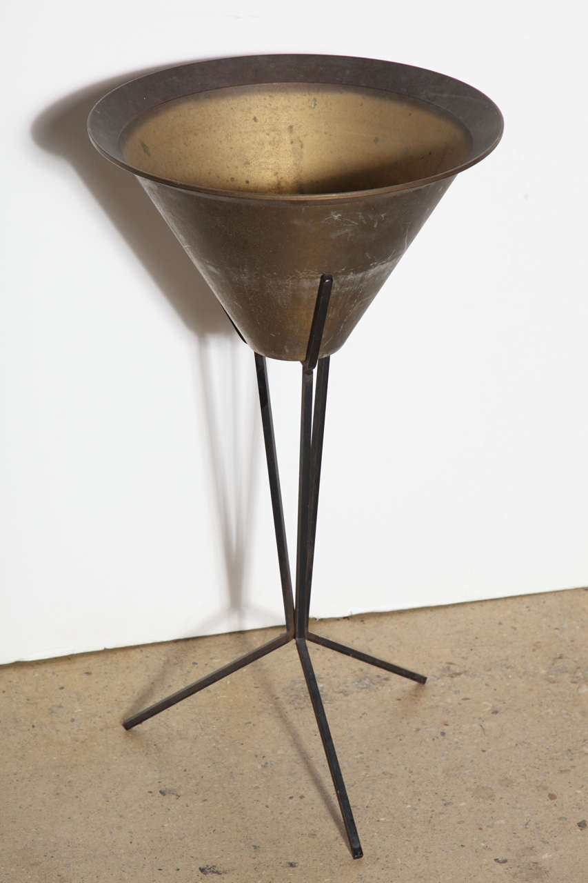 rare conical Brass and Wrought Iron Indoor Outdoor Plant Stand in the style of Paul McCobb.  The patinated Brass triangular shaped pot with outer ridge is seated atop a tripod Black Iron base