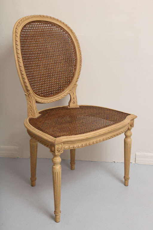 Four oval back caned side chairs.