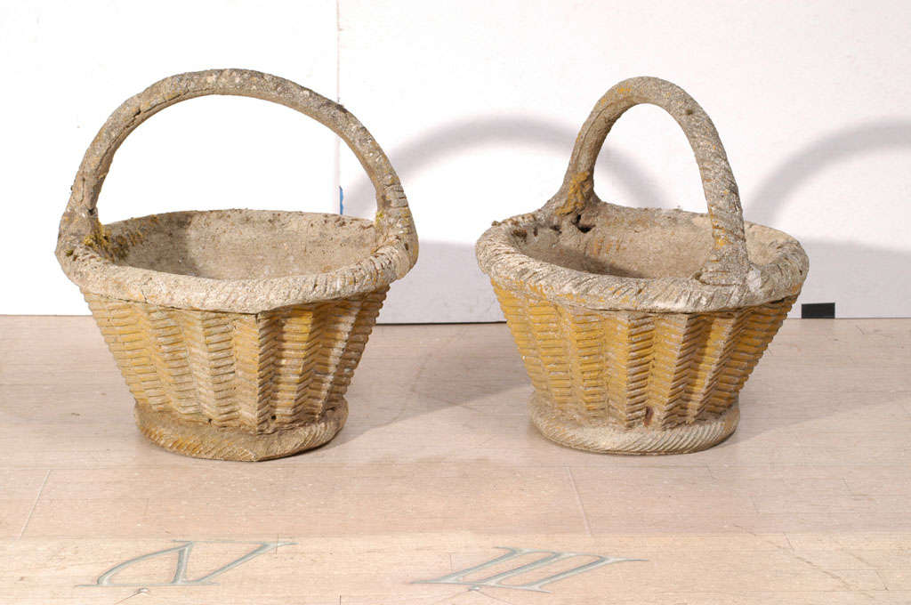 A pair of stunning lichen covered concrete baskets with saw tooth decoration all around
