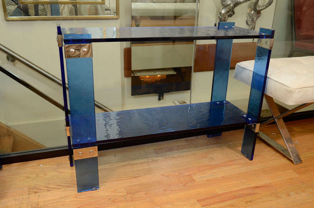 Two tier blue glass console table with chrome hardware
