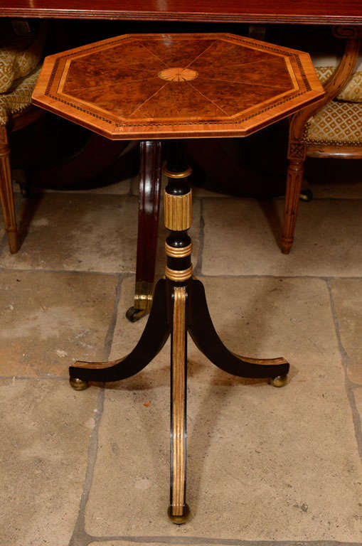 A fine English Regency burled yew wood and octagonal side table with satinwood and rosewood banding, on an ebonized and gilt tripod pedestal base.