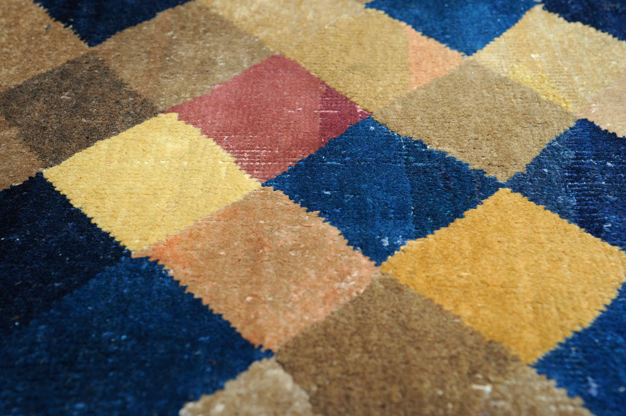 A fine Peking type carpet woven by an honeycomb arrangement of polychrome lozenges with an almost random color distribution. 
Carpets of this type are representative of an early 20th century 'Minimalist or Abstract' style which seems to characterize