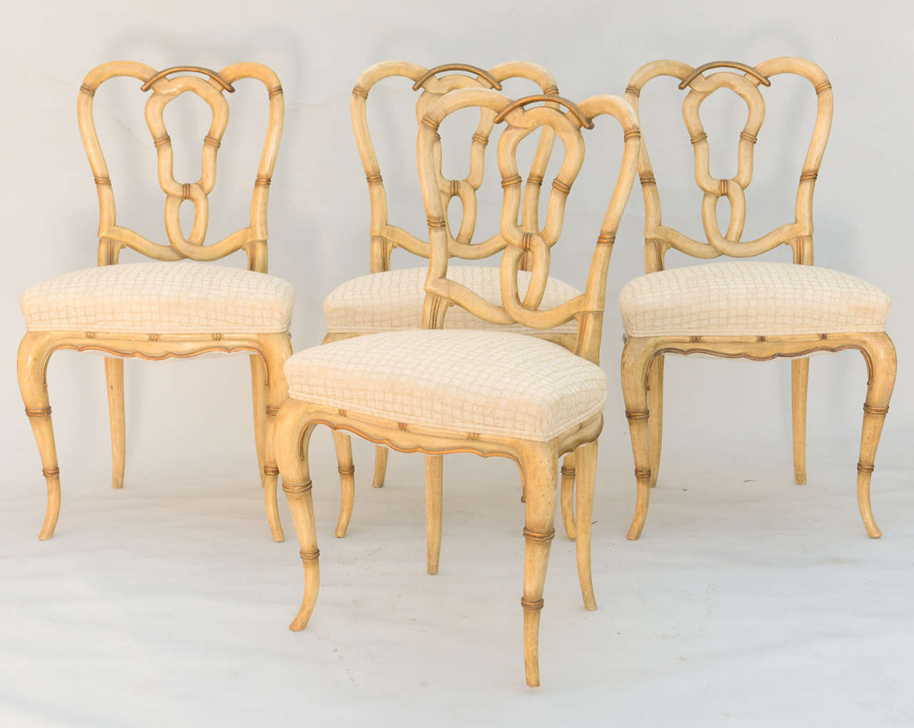Set of four painted chairs, of faux bamboo, each with upholstered shield shaped seat, raised on cabriole legs.

Stock ID: D9169