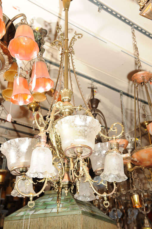 This highly ornate and graceful chandelier represents some of the highest style Victorian workmanship.  Note all the intricate brass work and fabulous original, deep-etched glass shades.  This fixture has four gas shades which point up, and four