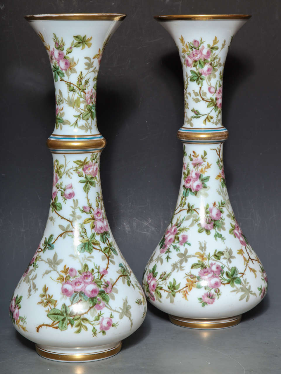 A large pair of antique French opaque white opaline glass, baluster shaped vases, finely painted with flowering vine, further decorated with 24-karat gold.
Attributed to "Baccarat", possibly painted by "JEAN-FRACOIS