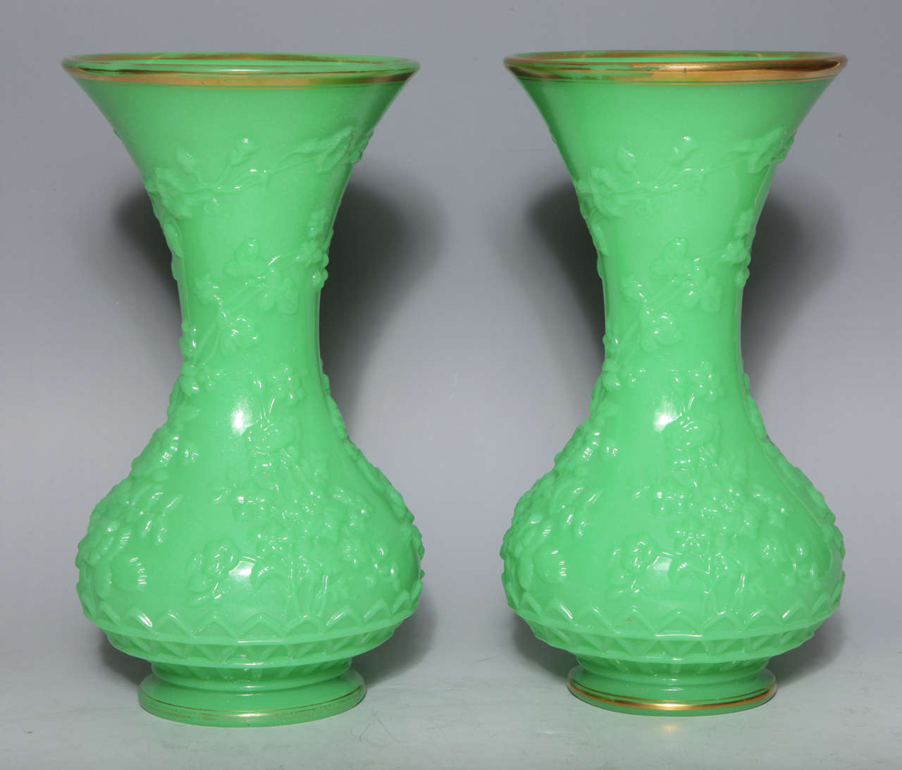 Paire de vases anciens en verre opalin vert de forme balustre, finement modelés avec des feuilles et des fleurs en repos,
attribué à 