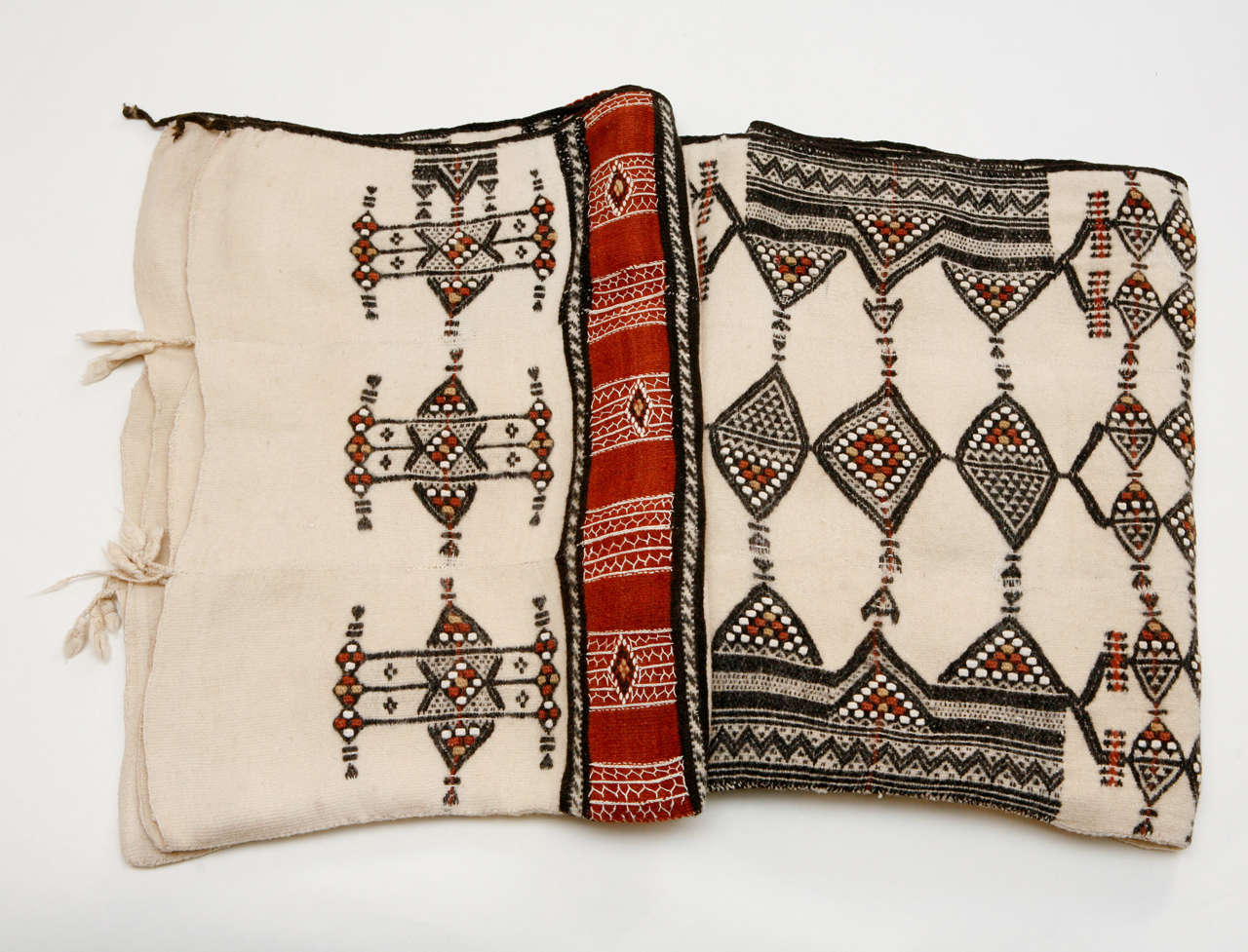 Spft white wool with red, black and brown inset weaving and embroidery.  Shown folded.  It is oblong,     x        .  Traditional blanket for Fulani tribal weddings  (West, Central and Sudanese Africa).