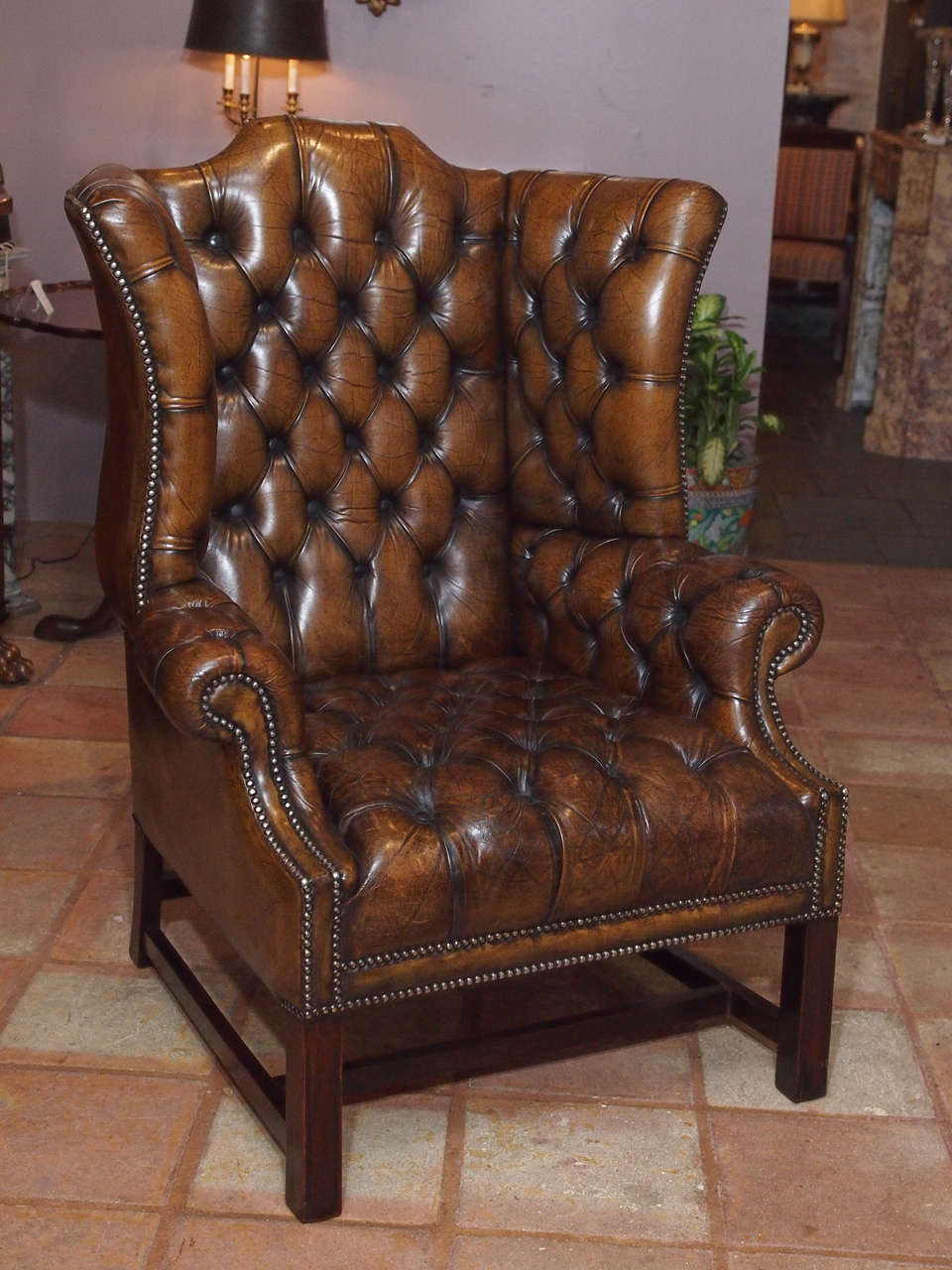 Antique English brown leather wing chair.  Circa 1870.
