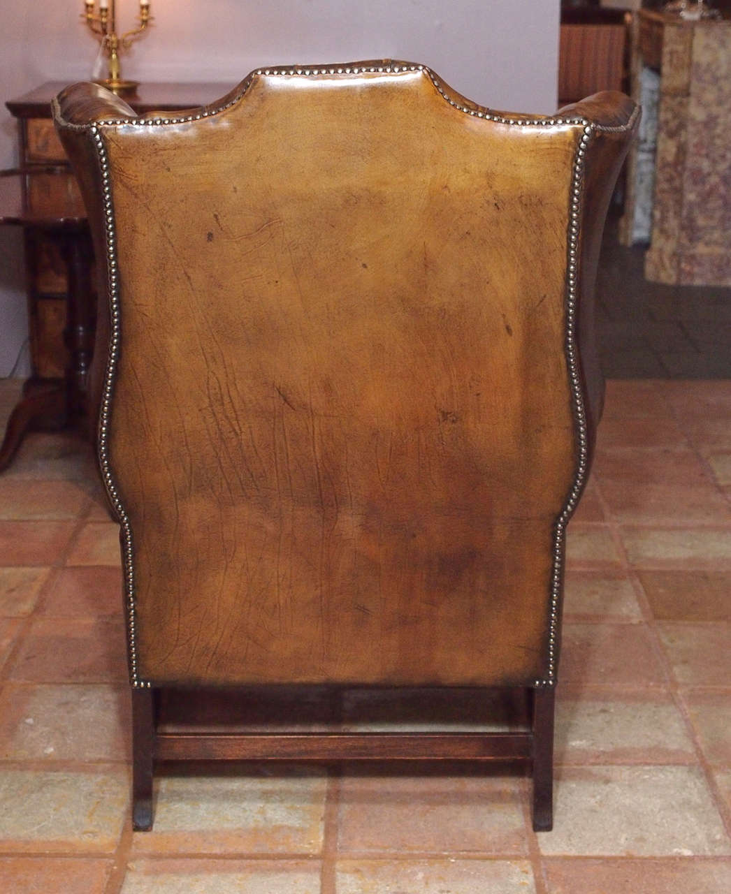 Antique English brown leather wing chair. 4