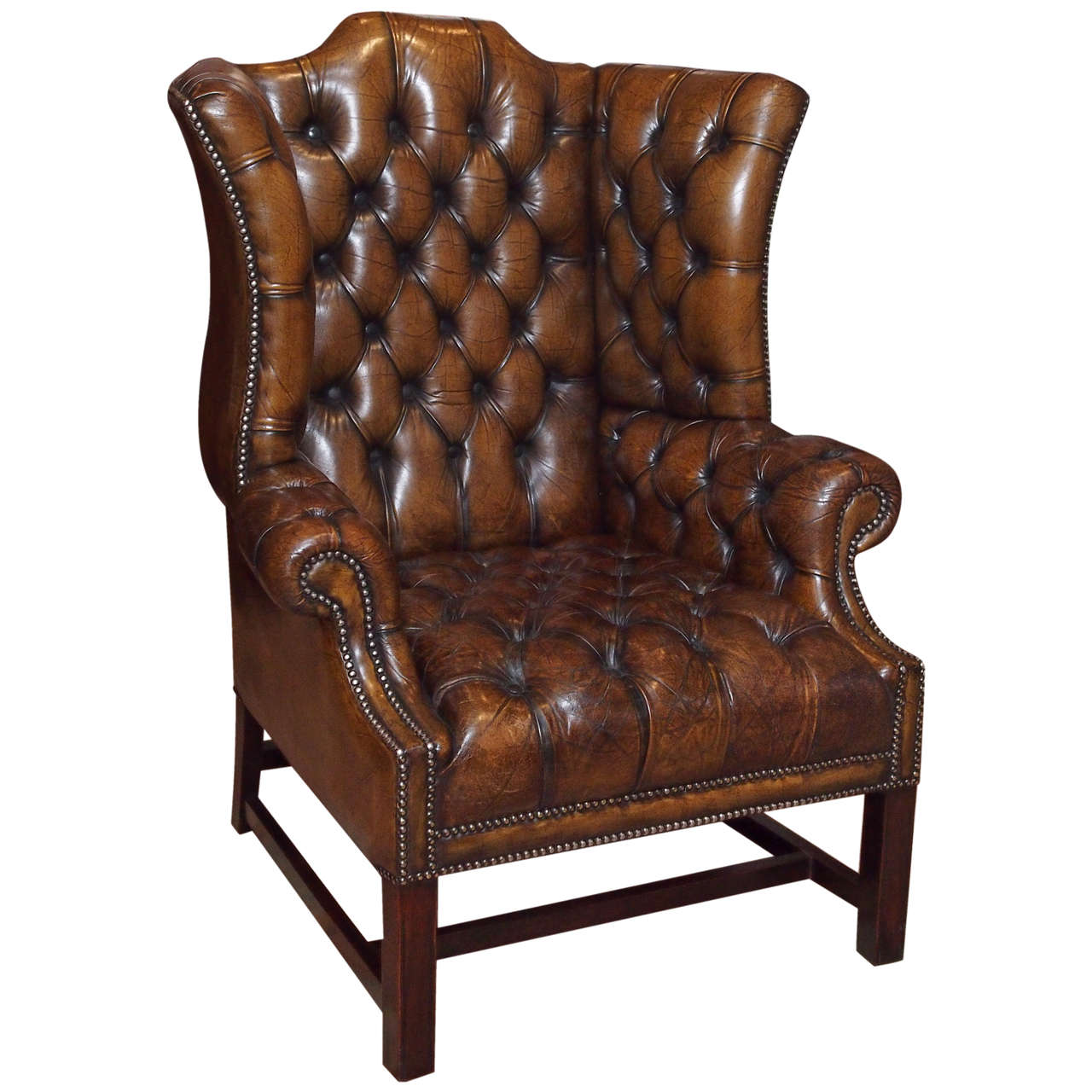 Antique English brown leather wing chair.