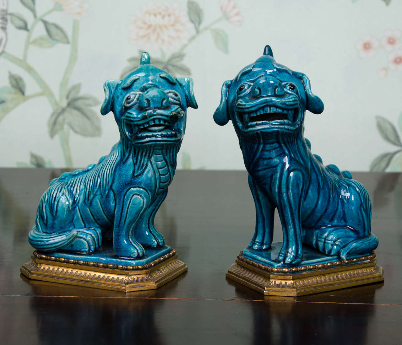 A fine and rare pair of Kangxi style Chinese turquoise glazed foo dogs on ormolu metal mounts. Both dogs are covered in a rich lustrous turquoise (peacock blue) glaze darkening which pools in the recesses. Both dogs date from the late 18th or early