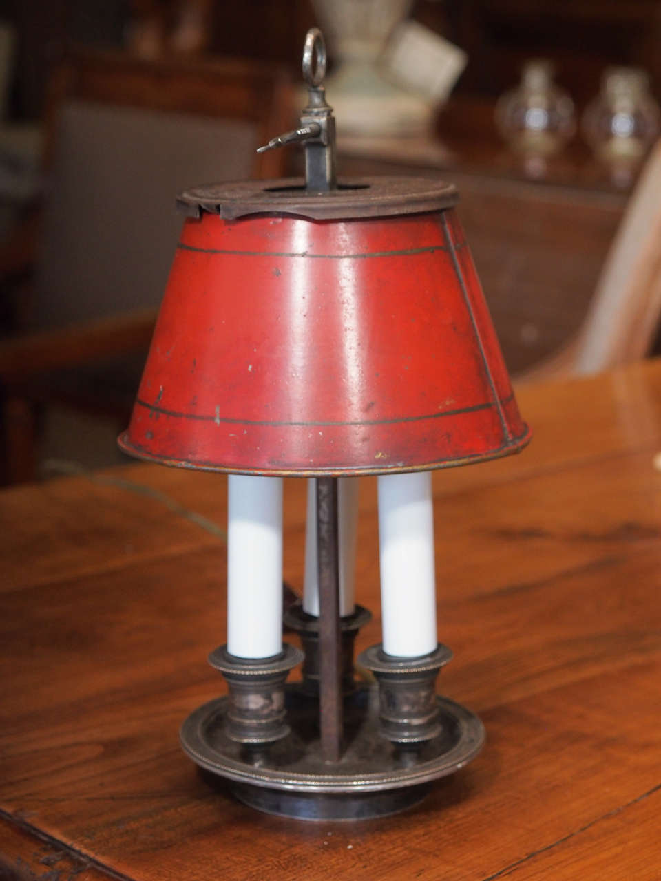 A diminutive silver plated bouillotte three-arm lamp with a red tole shade.