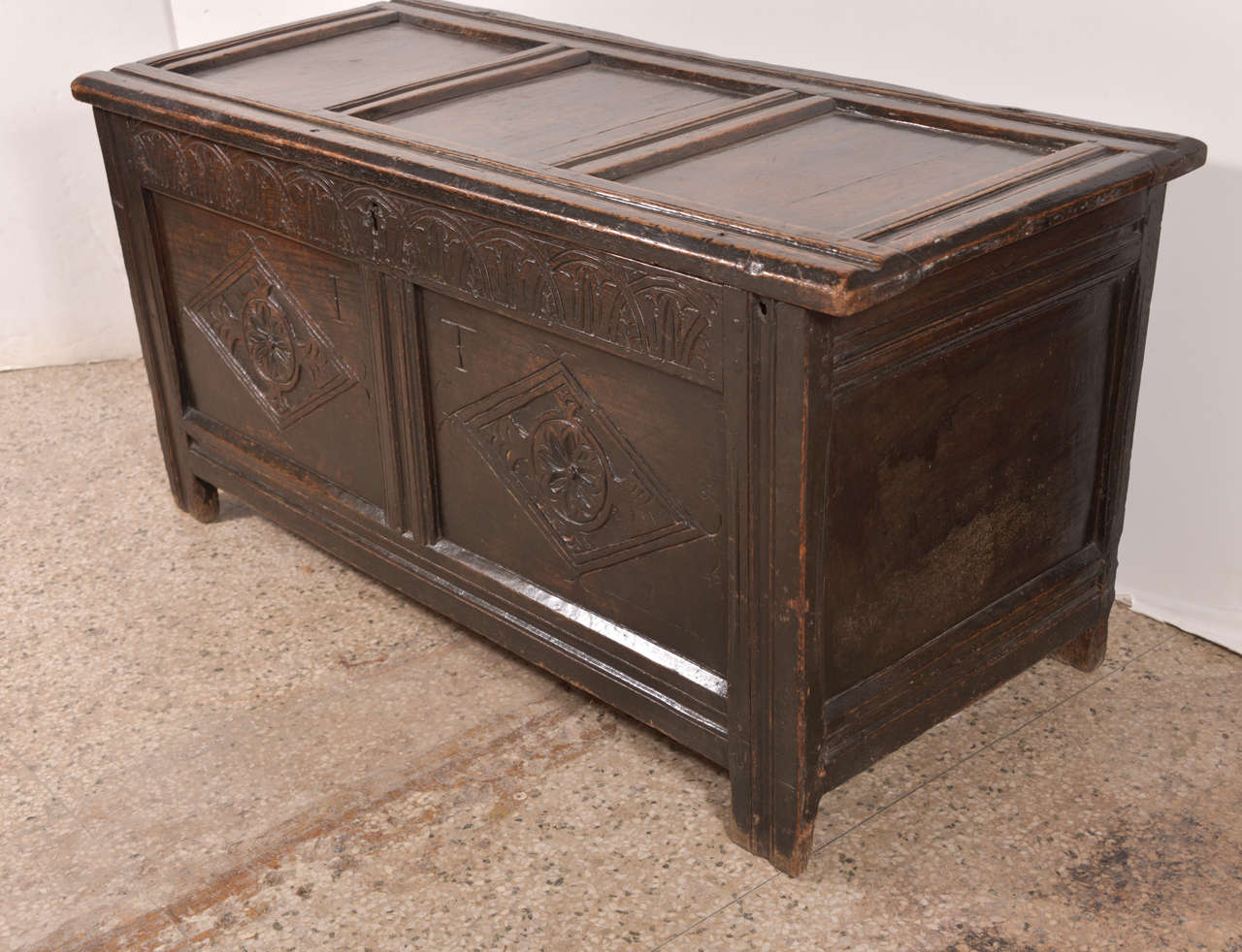 Early English oak chest: joined English paneled coffer, constructed in the late 17th or early 18th century. Used to store and protect a household's fine linens, clothing and valuables. 

This chest features carved nulling across the top of its front