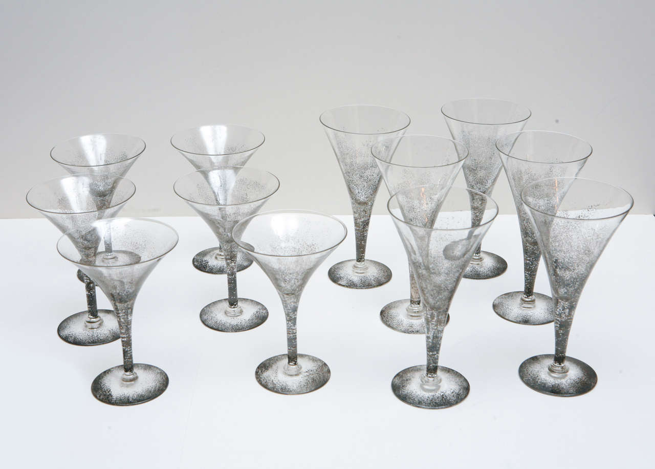 Set of six martini glasses and six champagne glasses that are hand decorated with silver. The silver viewed from within the glass is bright and not oxidized whereas the silver that is shown on the outside is dark and oxidized. Each set of six is