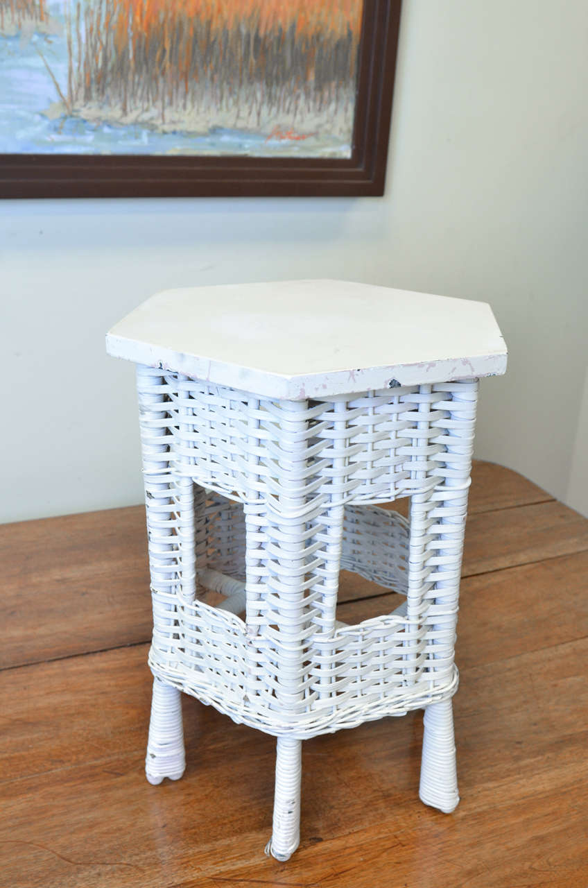 This is an American wicker small side table.  We sell a lot of this style for a drink's table beside a chair.  it is in excellent condition and has very little paint.