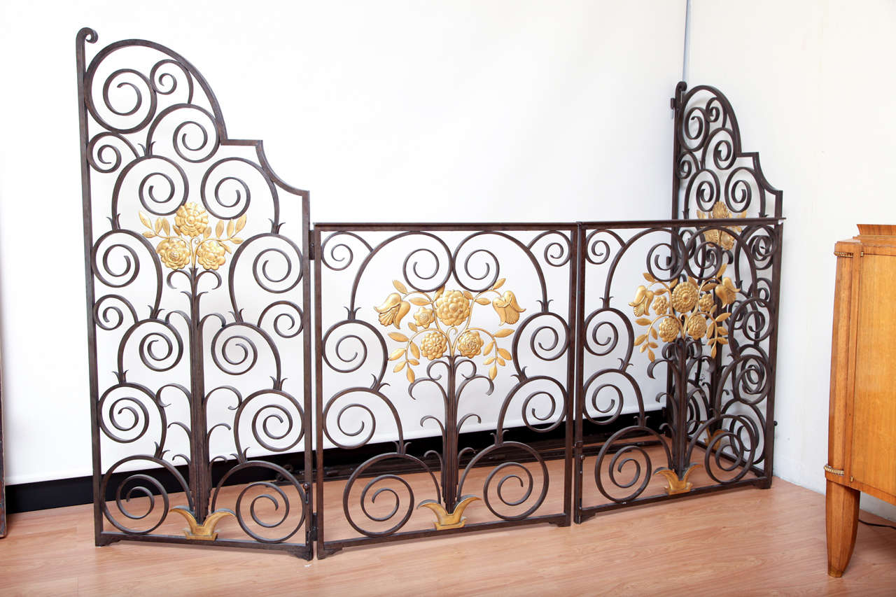 French, 1940s wrought iron double-sided gate, four leaves, each leaf decorated with a floral gilded wreath, marked Maeir. 
Height: 63.6 in, total length: 126 in.
