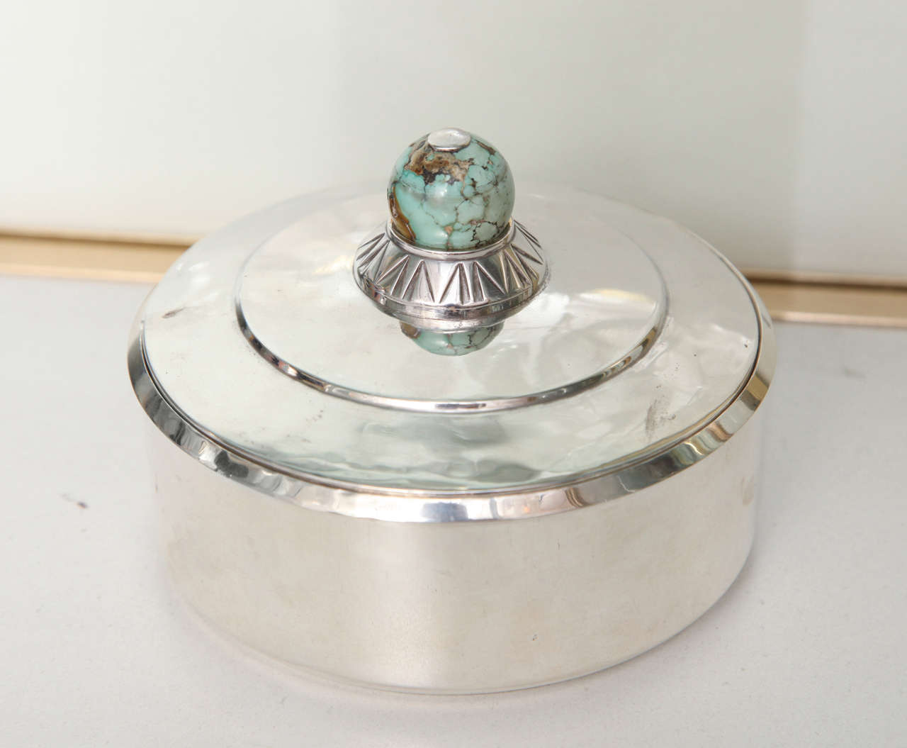 PUIFORCAT Jean Emile (1897-1945)
A French Silver and turquoise box, originally retailed by the Grogan Company
Signed Jean E. Puiforcat, Grogan Company Pittsburg Sterling France. Height: 3.5 in,  Diameter: 4.1 in
Weight: 237 g
.
