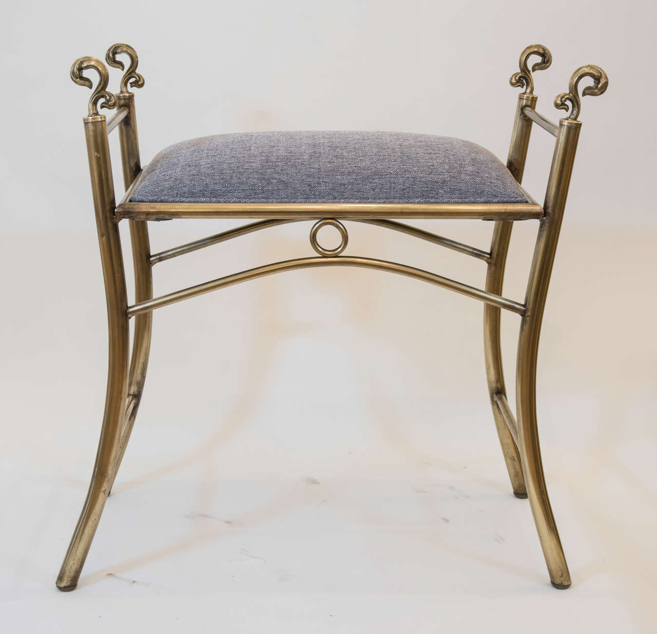 A perfect pair of polished brass
benches with decorative solid brass finials and new light grey
upholstery.