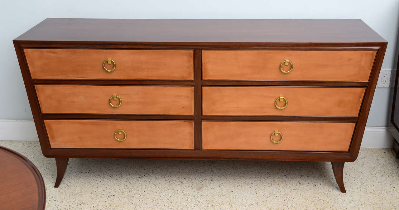 the rectangular top above canted sides on short splayed legs, the drawers all covered in fine kid glove leather and with brass ring pulls