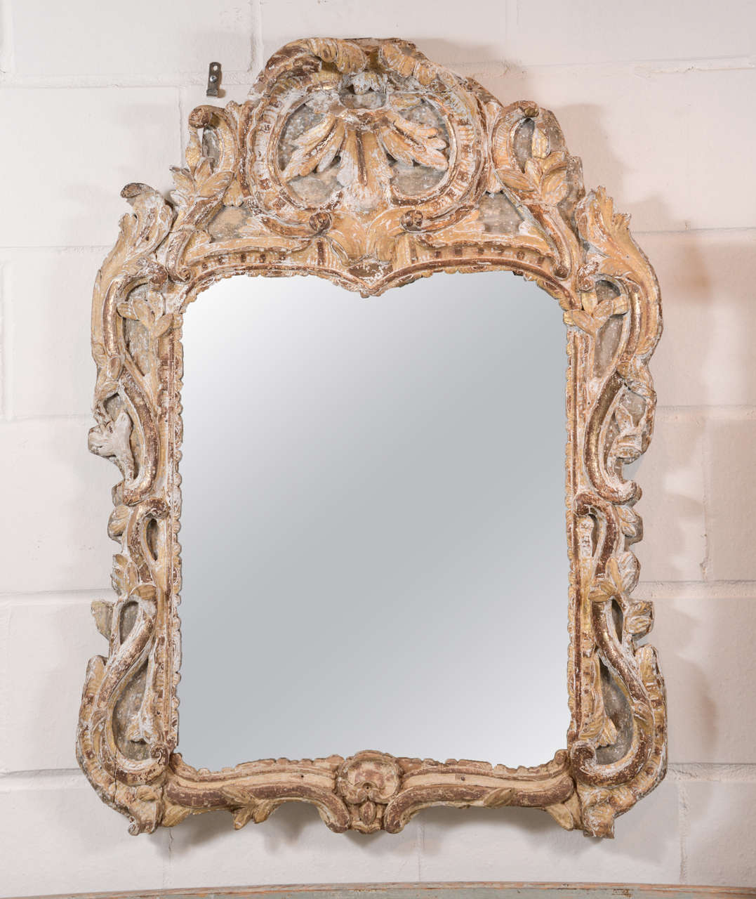 18th century Louis XV mirror with shell motif in crown. Original glass and traces of paint and gilt.