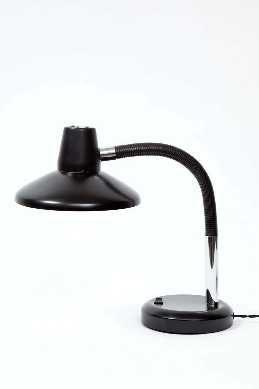 Clean-lined black plastic desk lamp with gooseneck arm and chromed metal accent.  USA, circa 1970.  On-off switch on base.