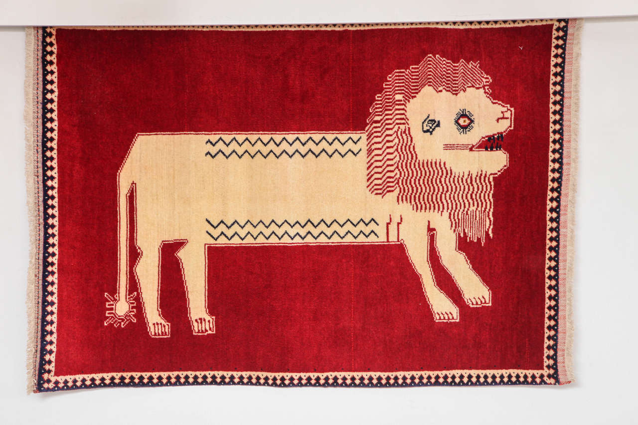 This 1940 Persian Qashqai carpet consists of a handspun wool warp, weft and pile and natural vegetable dyes. Although the color palette of rich red and natural beige is minimal compared to other Qashqai animal rugs, the effect is rather striking,