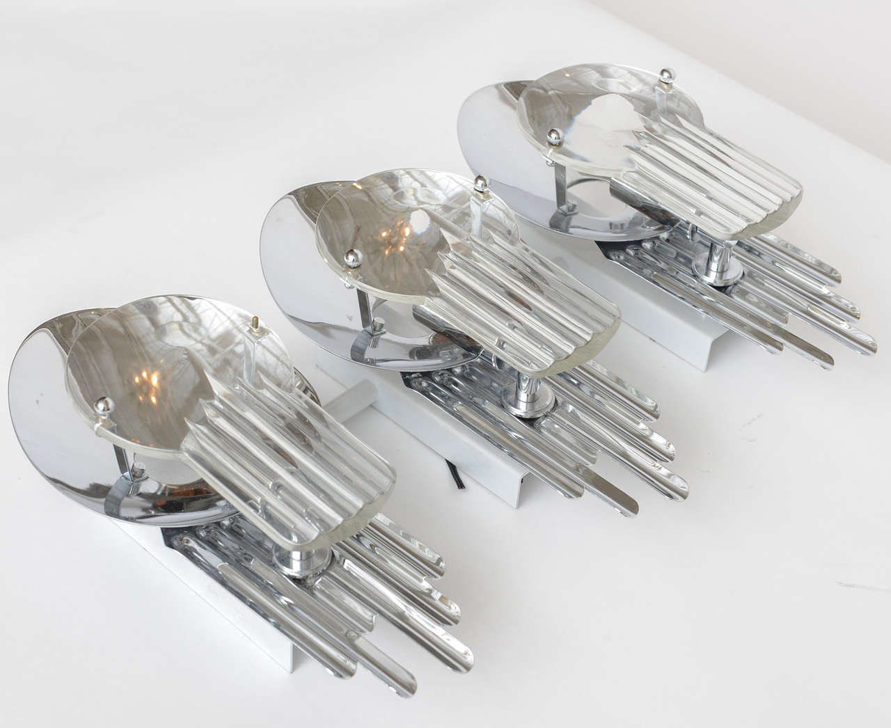 Pair of 1960s Italian three-light wall sconces by Gaetano Sciolari. Fluted chrome reflectors with molded optical glass.