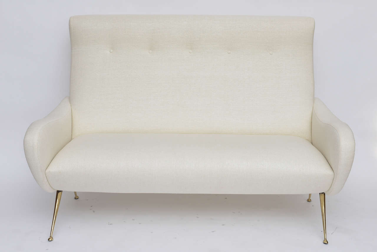 Our own production 50's Italian-inspired settee. Legs are solid cast bronze, available in brushed or polished finish (as shown here), or to-order in nickel, gunmetal, antiqued bronze, or copper plate. Available in a richly textured cream-colored