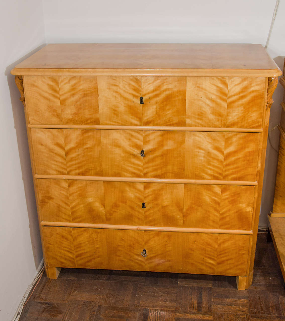 Crafted of birch and fir the four deep drawers are expertly veneered with hand-cut, book matched Nordic birch veneers and lock with original locks, keys and inset escutcheons. This masculine, minimally decorated chest rests on solid block feet.