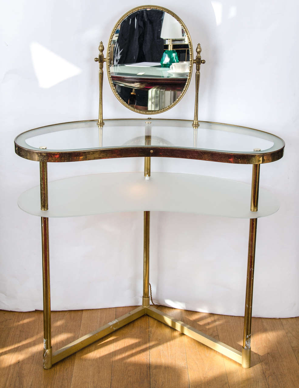 Two-tiered 1950s Dressing Table with integral oval mirror, the lower shelf in etched glass and having a switch operating a fitted light, all on a tripod base