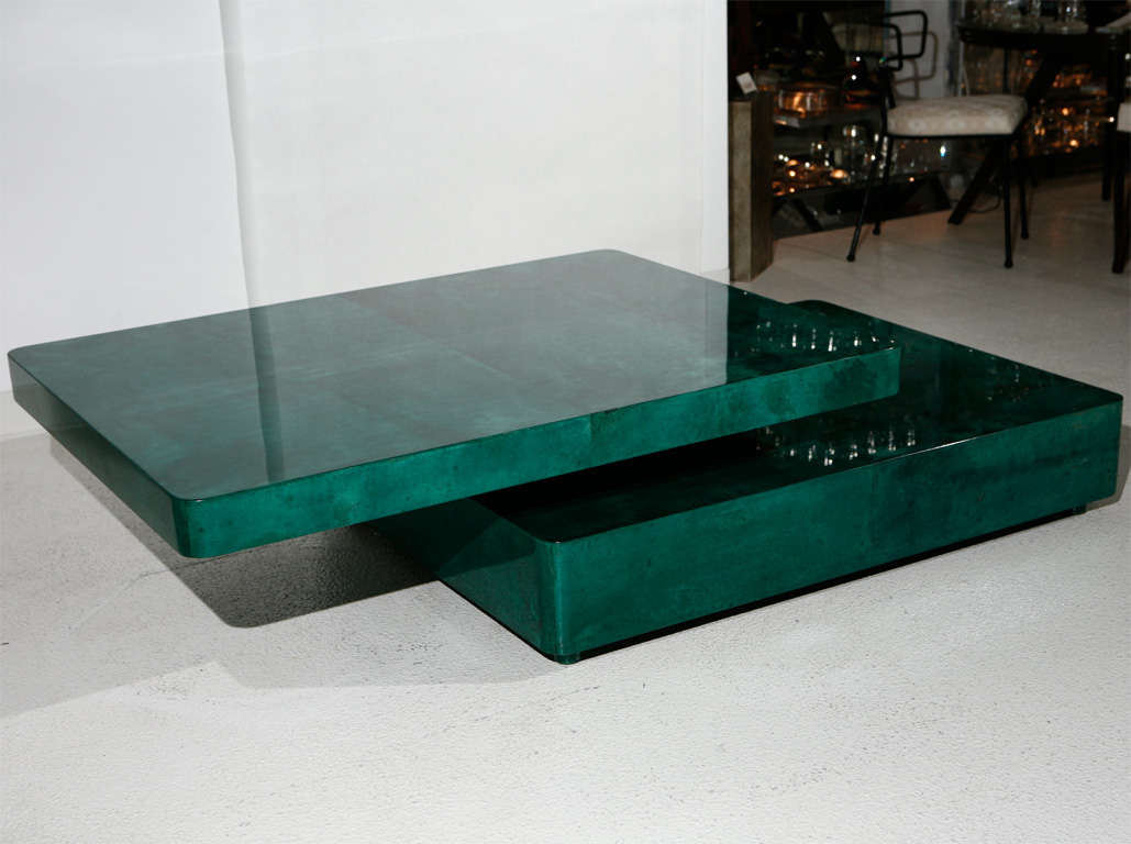 Spectacular two-tier cocktail table completely veneered in lacquered freeform green parchment.  Top tier glides to one side, as seen in the photos which extends the overall table length to 67