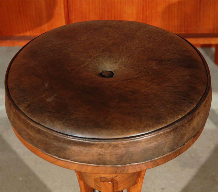 Adjustable teak stool w/distressed black leather upholstered seat