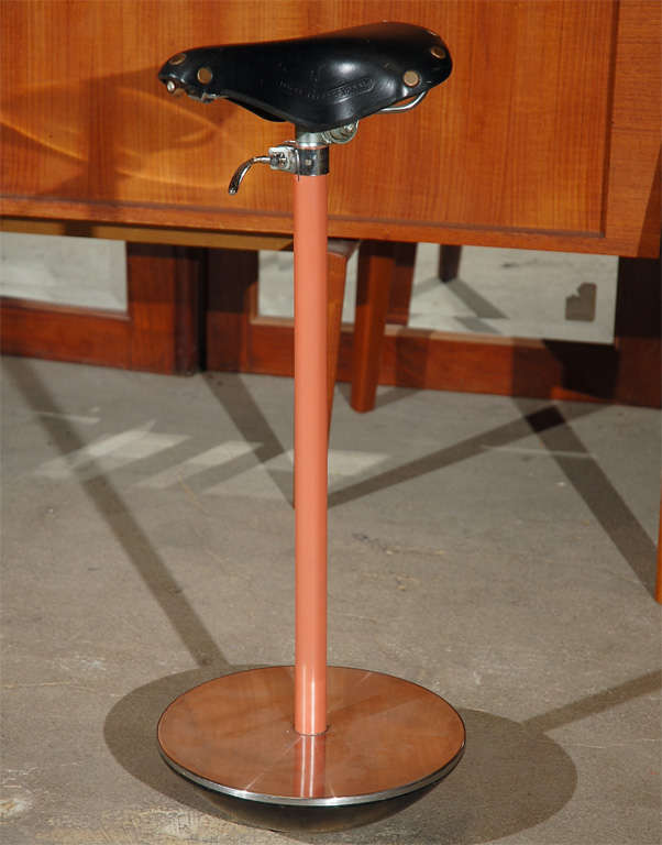 Stool made from a black bicycle seat w/a lacquered steel column & cast iron base