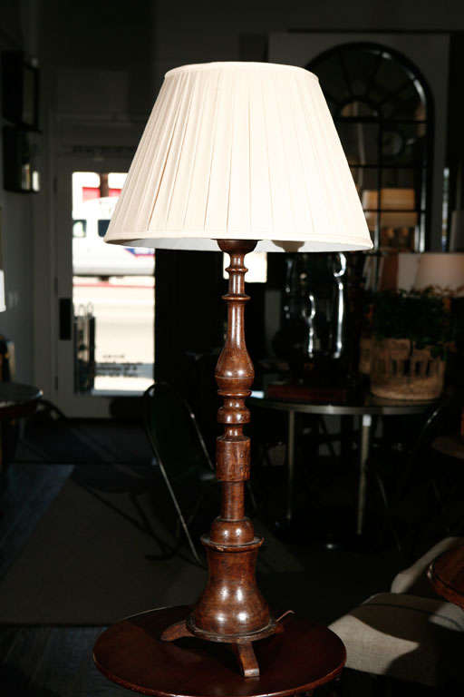 A tall turned tripod post as a lamp fitted with a custom pleated shade. This lamp is a great example of a simple classical form executed in an honest material. This example dates back to the 1820s and was made in England. 
