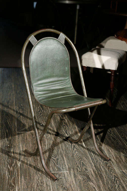 Pair of unique metal arch back chairs with open frames and green leather seat backs from 1940s England. Great as accent chairs or dining chairs, the muted coloring and unique patina give these chairs a luxurious yet industrial feel.

England, circa