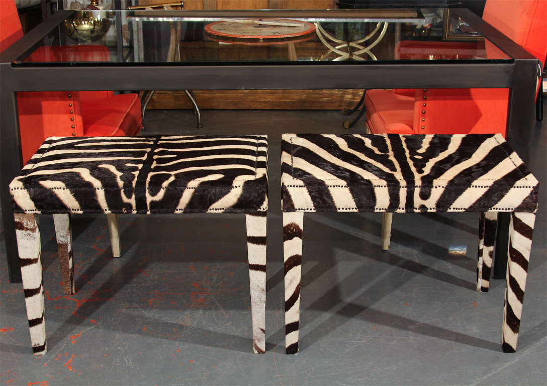 single bench/side table upholstered in 1960's zebra hide.  perfect as side table, doubles as extra dining room seating.  Bench on right is sold