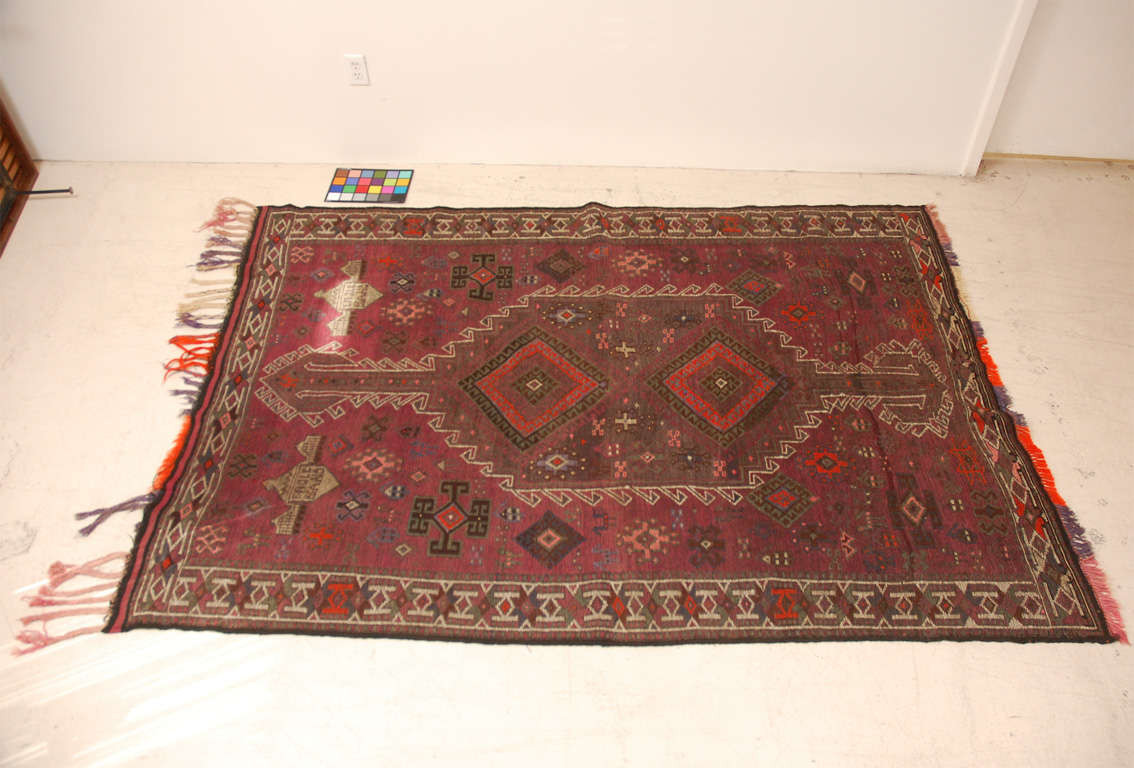 Vinatage patterned Turkish rug.  * White rectangle is not a stain but a light spot.  Unsusual purple hue to field