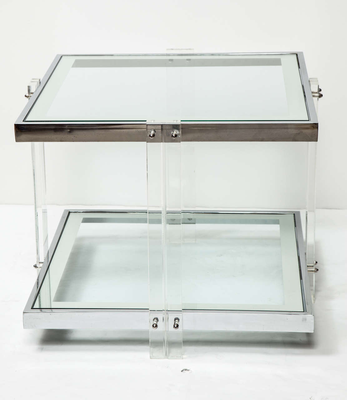 Decorative side table deigned of Lucite and chrome, circa 1960. Two glass shelves with silver borders.